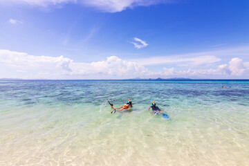 Fototapeta na wymiar Tourist snorkeling in turquoise sea with blue sky of Bamboo island or Koh Mai Pai. Phi Phi island national park in Krabi, Thailand. Bamboo island (Koh Phai in Thai) 