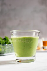 Healthy green kale smoothie with greek yogurt, almond and honey in glass isolated on white table background. Kale is considered a superfood because it's a great source of vitamins and minerals.