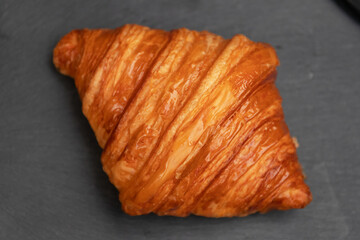 Freshly baked croissants just out of the oven on black stone background.