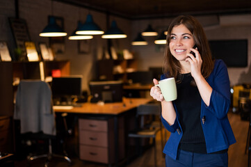 Woman using mobile phone at work in the office.