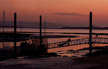 Fototapeta premium Twilight image of boats and jetty in silhouette on an English estuary