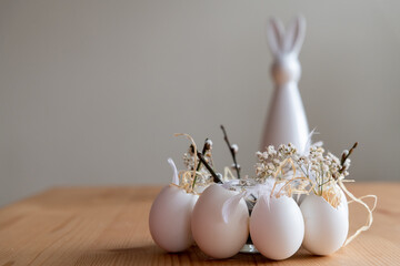 Osterhase im Hintergrund mit weißen Eiern im Vordergrund als Dekoidee zu Ostern. Querformat.