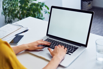 Closeup of woman using laptop with white blank screen mockup - obrazy, fototapety, plakaty