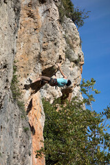 man climbing a mountain with rope