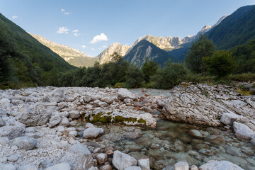 The last light of the day hits the mountain peaks withthe river Lepena in foreground