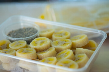 Delicious boiled banana served with black sesame mix sugar in box.