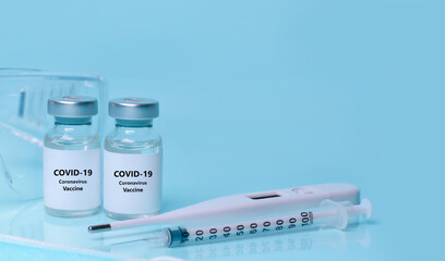 Medical bottles, vials,vaccine, syringe , face mask,body thermometer and protective glasses. The concept of medicine, healthcare, science.Coronavirus vaccine, immunity improvement.Copy space for text.