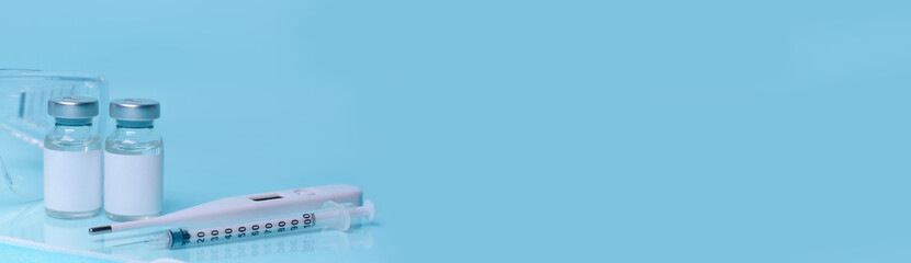 Medical bottles, vials,vaccine, syringe , face mask,body thermometer and protective glasses. The concept of medicine, healthcare,  science.Coronavirus vaccine,  immunity improvement.Copy space.