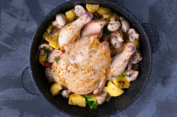 Whole raw chicken marinated in mustard, oil and spices in the stewpan prepared for cooking in the oven. Making roast