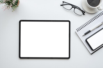 White office desk with smartphone tablet white screen empty at the office. Mock up.