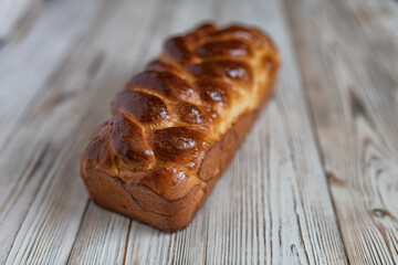 A loaf of fresh white wheat bread on a wooden background.