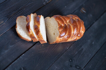 A loaf of fresh white wheat bread on a wooden background.