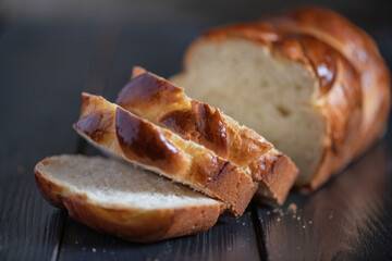 A loaf of fresh white wheat bread on a wooden background.
