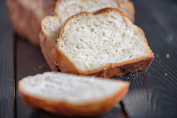 A loaf of fresh white wheat bread on a wooden background.