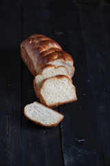 A loaf of fresh white wheat bread on a wooden background.