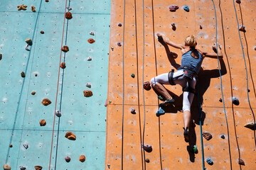  girl climbing up the wall