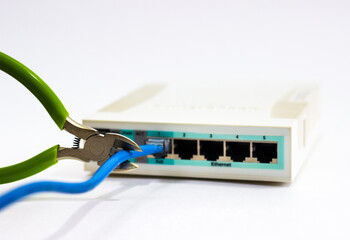 Cuts cable on router. Man cuts cord of Wi-Fi router. White router with cut cord. Side cutters cut...