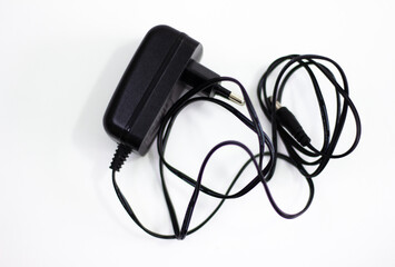 Black power adapter on white background. Charging adapter with cable. DC + 5 ~ 9V 5.5 * 2.1MM adapter on white background. Black power supply with cable on white background.