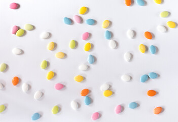 Easter almonds spread on white, pattern and floral table cloth as background