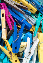 Many colored plastic clothes pegs close up. Lots of clothespins