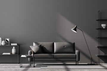 Modern living room interior, black wall. Dark grey 2 sitter sofa with cushion, coffee table, shelves and lamp. Concrete floor.