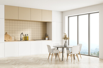 Modern kitchen interior, dining area with panoramic windows. Furnished by table and chairs for eating. Parquet floor.