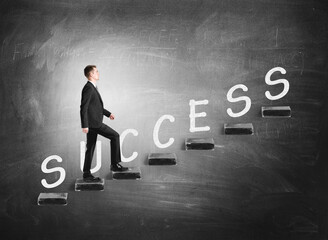 Businessman going up on stairs with success letters on black background