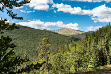 Fototapeta premium A beautiful view of the rocky mountains, with blue sky and puffy clouds. Concepts of travel, outdoor recreation, and nature