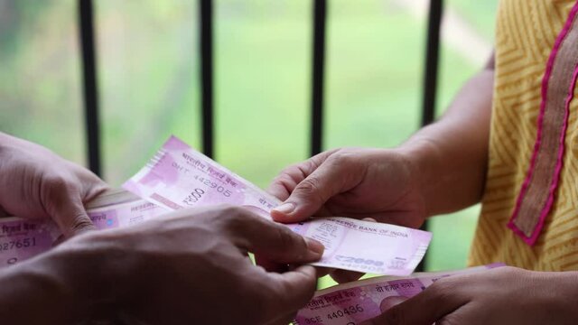 Counting Indian currency Rupee , hand paying salary giving Indian money 2000 rupees banknote Kerala India 4K slow motion video, footage. Business woman borrowing money cash new Indian currency notes