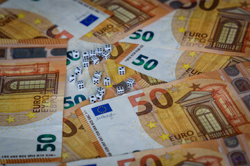 several white dice and euro money