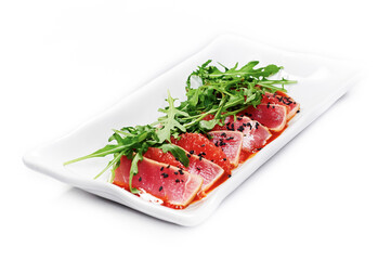 Salmon served with a grapefruit sauce, arugula and black sesame seeds