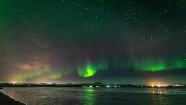 Green and purple Aurora Borealis dancing above horizon in Iceland - time lapse video