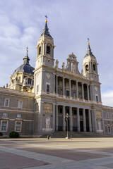 Fototapeta na wymiar Main facade of the Almudena cathedral in Madrid on sunny day with clouds.