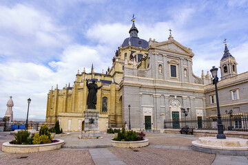 Fototapeta premium Main entrance of the Almudena cathedral in Madrid, blue sky with clouds.