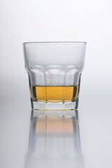 Whiskey in the glass reflecting on smooth surface