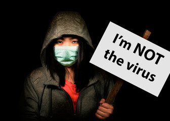 Chinese woman at demo with Im not a virus billboard - young upset Korean woman in anti covid19 face...