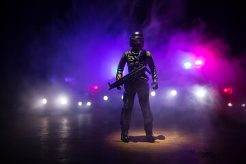 Anti-riot police give signal to be ready. Government power concept. Police in action. Smoke on a dark background with lights. Blue red flashing sirens. Dictatorship power