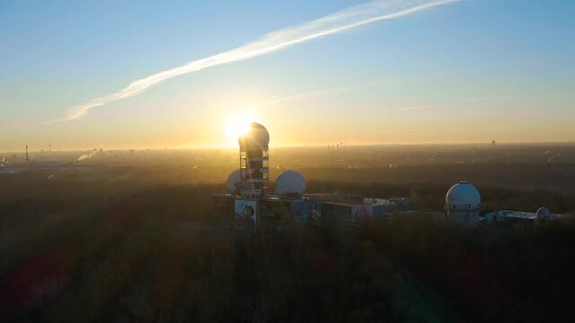 flying over abandoned surveillance station in berlin during bright sunrise