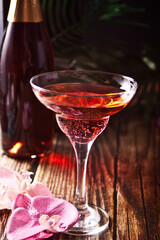 Summer tropical pink cocktail decorated orchid flower on the wooden background