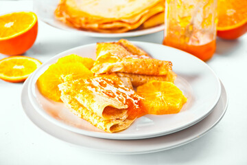 Thin pancakes crepes with orange fruit and sweet sauce marmalade