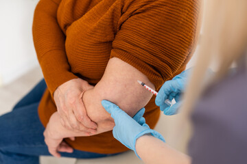 Obraz premium Nurse making vaccine injection to elderly patient