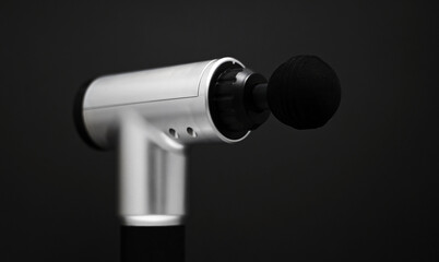 Massage percussion device on black background. Suitable for advertising.