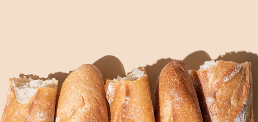 Pieces of crispy baguette on a yellow background in sunlight, banner.