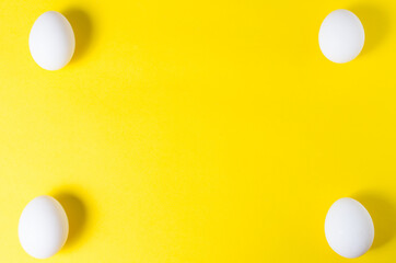 four eggs lie on the edges of the yellow background. .there is free space