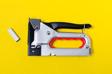 Staple guns on yellow background