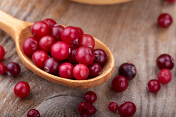 Ripe cranberries in a wooden spoon.
