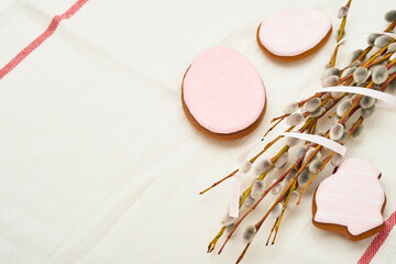 Easter. Pussy willows branches yellow ribbon and easter gingerbread hares, chickens and eggs  isolated on a white background.