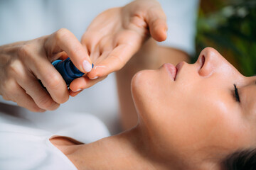 Retinol Treatment. Cosmetician Applying Retinol Serum on Woman’s Face