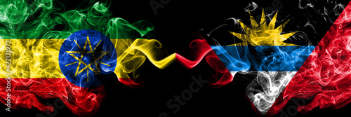Ethiopia, Ethiopian vs Antigua and Barbuda, Antiguan and Barbudan smoky mystic flags placed side by side. Thick colored silky abstract smoke flags.