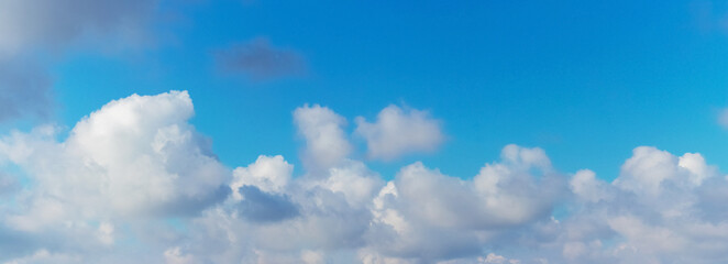 Blue sky with curly white clouds, panorama